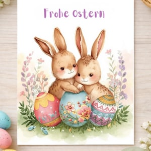 May include: A watercolor Easter greeting card featuring two brown bunnies embracing a blue egg decorated with flowers. The card includes the text "Frohe Ostern" in purple and the words "Digital Download". Other decorated eggs and flowers are in the background.