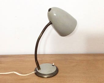 Gray mid-century modern gooseneck industrial desk lamp or table lamp with round metal base and brass detailing.