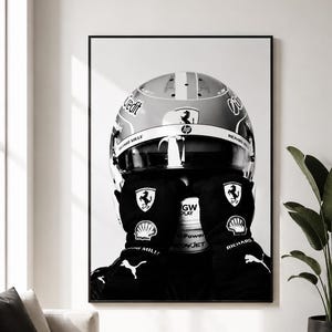 May include: A black and white framed wall art print featuring a racing helmet and gloves. The helmet displays logos including Ferrari, HP, and Richard Mille. The black gloves feature the Ferrari prancing horse, Shell, and Puma logos prominently.