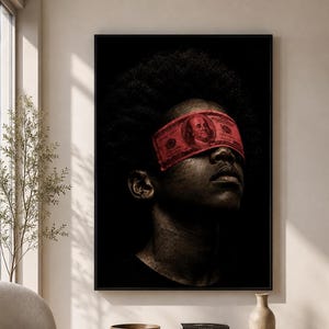 Puede incluir: Una impresión de arte mural enmarcada que muestra el retrato de una persona de piel oscura y cabello texturizado, con un billete rojo de cien dólares a modo de venda sobre los ojos. El fondo es negro sólido, resaltando los rasgos faciales.