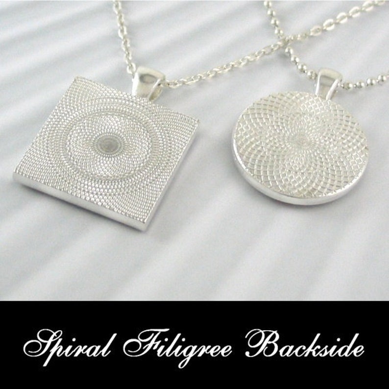 May include: Two silver necklaces with pendants. One pendant is a square with a spiral design, the other is a circle with a spiral design. The text "Spiral Filigree Backside" is at the bottom of the image.