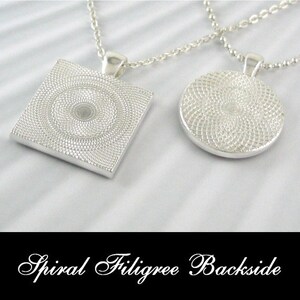 May include: Two silver necklaces with pendants. One pendant is a square with a spiral design, the other is a circle with a spiral design. The text "Spiral Filigree Backside" is at the bottom of the image.