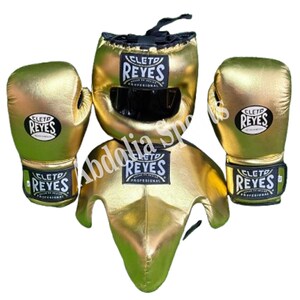 May include: A gold boxing set including gloves, headgear, and a groin protector. Each piece features the "CLETO REYES" logo in black and white. The set is designed for professional use.