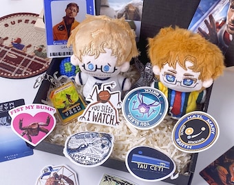 May include: A gift box containing two plush dolls with blonde hair and glasses, a G.C.M.S. identification card, and various stickers featuring space-themed illustrations, including text like "Fist My Bump!", "You Sleep I Watch", and "Hail Mary Earth".
