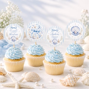 Puede incluir: Cuatro cupcakes con glaseado azul claro y chispas blancas, cada uno con un adorno de papel circular con rayas azules y blancas, acuarelas de conchas, estrellas de mar y lazos. Dos adornos incluyen los textos The Summer I Turned Thirteen y Sophia's Birthday Party.