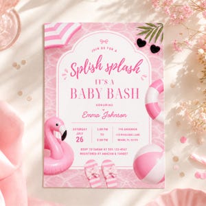 May include: Pink baby shower invitation with a pool party theme. The invitation features a flamingo, beach ball, and text that reads "Splish Splash It's a Baby Bash". The date is July 26th.