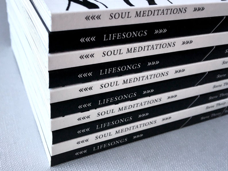 May include: A stack of books with black and white covers. The covers have the text "Soul Meditations" and "Lifesongs" repeated on each book.
