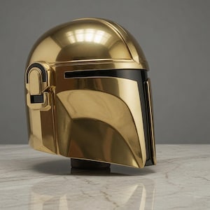 May include: A polished gold-colored helmet featuring a smooth, rounded dome and a T-shaped black visor. The side of the helmet displays a raised rectangular ear piece with black accents, and the overall design has a reflective, metallic finish.