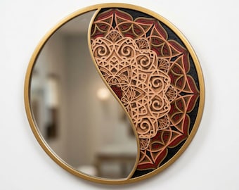 Pode incluir: Um espelho de parede circular com moldura dourada. Uma metade do espelho é de vidro refletor, enquanto a outra metade apresenta um design de madeira cortada a laser, multicamadas e complexo, em tons de vermelho, preto e madeira natural.