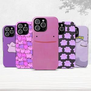 Op de afbeelding: Een verzameling van vijf telefoonhoesjes met het Pokémon-personage Ditto. De hoesjes zijn in verschillende tinten paars en roze, met verschillende ontwerpen, waaronder Ditto's gezicht en een patroon van Ditto-vormen.