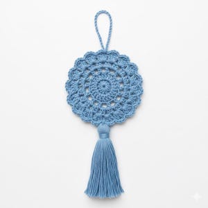 May include: A light blue, handmade crochet ornament with a circular doily design and a tassel. The ornament has a loop for hanging. The crochet work features a detailed, openwork pattern. The tassel is made of the same light blue yarn.