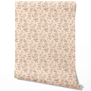 May include: A roll of wallpaper featuring a repeating floral pattern. The design includes large, stylized flowers in shades of pink, cream, and green against a pale pink background. The wallpaper is rolled up, showing the pattern's edge.