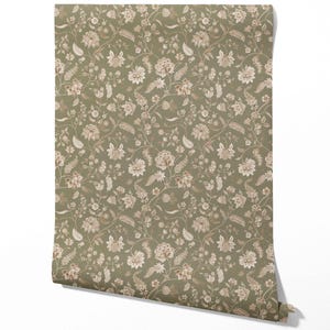 May include: A roll of wallpaper featuring a repeating floral pattern. The design includes detailed flowers and foliage in shades of beige and white against a muted green background. The wallpaper is unrolled, showing the pattern's full repeat.