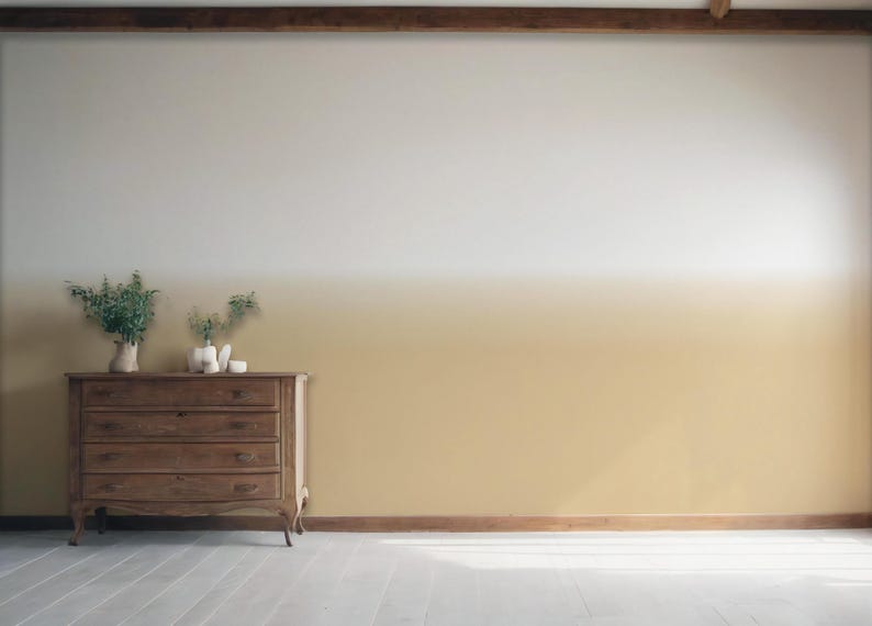 May include: A wooden chest of drawers with four drawers sits against a wall featuring a horizontal ombre paint effect that transitions from a warm golden yellow at the bottom to a crisp white at the top, with green foliage in vases on top.