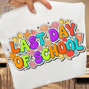 Könnte beinhalten: Weiße Tragetasche mit einem farbenfrohen Grafikdesign mit der Aufschrift "LAST DAY OF SCHOOL". Das Design umfasst Muscheln, Seesterne, Schleifen, Äpfel und ein Buch. Der Text ist im Bubble-Letter-Stil mit schwarzer Umrandung.