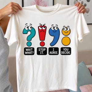 Może przedstawiać: Biały t-shirt z grafiką przedstawiającą cztery kolorowe znaki interpunkcyjne z oczami i twarzami z kreskówek. Symbole obejmują turkusowy znak zapytania, czerwony wykrzyknik, niebieski przecinek i żółty dwukropek, każdy z tekstem: WAIT WHAT?, STOP IT., I AGREE., YOU DECIDE.
