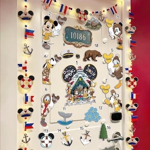 May include: A white door decorated with Disney-themed cutouts, including Mickey Mouse, Donald Duck, and Goofy. The door also features anchors, flags, and the text "The Smith Family".