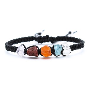 May include: A black macrame bracelet featuring a series of colorful, raw gemstones. The stones include clear, red, orange, blue, and white hues. The bracelet is adjustable and sits against a white background.