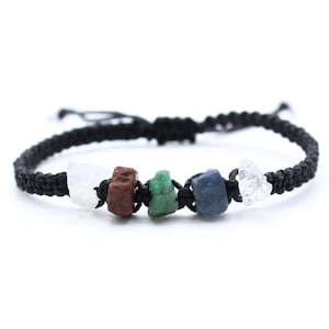 May include: A black macramé bracelet with five raw gemstones in white, brown, green, blue, and clear. The bracelet is adjustable and is displayed against a white background. The gemstones are of varying sizes.