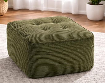 Puf otomano grande de pana, asiento con cojín cuadrado capitoné y reposapiés de espuma viscoelástica negra.