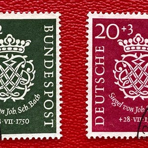 Peut inclure: Deux timbres-poste rectangulaires représentant le sceau de Johann Sebastian Bach. Un timbre est vert foncé avec une valeur de 10+2, l'autre est magenta avec une valeur de 20+3. Les deux portent le texte DEUTSCHE BUNDESPOST et 28.VII.1750.