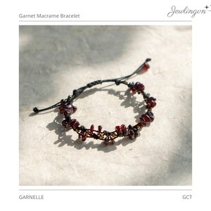 May include: A macrame bracelet featuring dark red garnet gemstone chips interspersed with small metallic beads on a black cord. The bracelet includes an adjustable sliding knot closure with two dangling ends, each finished with a single garnet bead.
