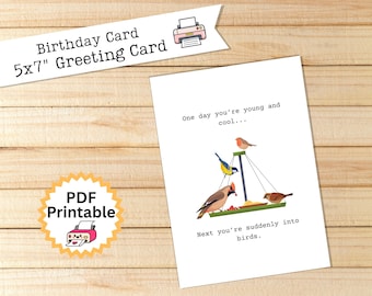 May include: A white 5x7" birthday greeting card with the text "One day you're young and cool... Next you're suddenly into birds." The card features illustrations of colorful birds at a bird feeder. A "PDF Printable" sticker is in the lower left corner.