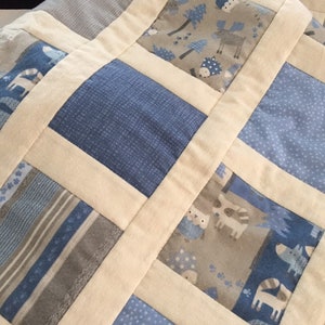 Blue, white and gray flannel baby quilt.  40x32 patchwork pieced baby quilt with cotton batting, flannel backing.  Machine quilted.