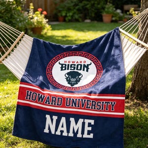 May include: A navy blue towel with the words "HOWARD UNIVERSITY" in white and red. The towel has a circular logo with a bison and the word "BISON". The word "NAME" is also visible.