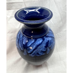 Pode incluir: Um vaso de cerâmica com uma borda larga e alargada e um corpo bulboso. O esmalte apresenta uma cor base azul-marinho profunda e escura que transita para um padrão azul cobalto manchado mais claro na parte superior, com acabamento brilhante.