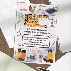 May include: A printed poster with the text "LET'S BEAT THOSE TASKS TOGETHER!" and illustrations of a laptop, drinks, and people using devices. The poster is on a wooden surface with notebooks and a pen.