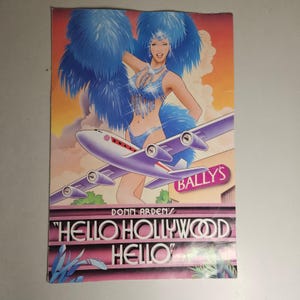 Könnte beinhalten: Ein Vintage-Poster mit einer Showtänzerin in einem blauen Paillettenkostüm mit großen blauen Federbüscheln, platziert hinter einem stilisierten Flugzeug. Der Text lautet Donn Arden's Hello Hollywood Hello und Bally's vor einem Abendhimmel.