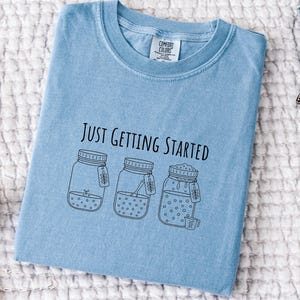 Koszulka "Właśnie zaczynamy" z zakwasem, Przytulna koszulka z estetyczną grafiką do pieczenia, Prezent dla niej z automatu do pieczenia chleba, Zabawna koszulka z ciastem startowym, Koszulka w komfortowych kolorach