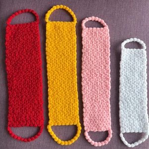 Può includere: Quattro colorate spugne da bagno fatte a mano in rosso, giallo, rosa e bianco. Ogni spugna è rettangolare con un manico ad anello nella parte superiore e un fondo arrotondato. Le spugne hanno un motivo strutturato a forma di stella.