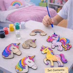 May include: A craft kit featuring wooden unicorn figures, paints, a brush, and varnish. The kit includes a figure measuring 13-15 cm, six paint pots, a brush, varnish, and a personalized stand. The unicorns have colourful manes and tails.