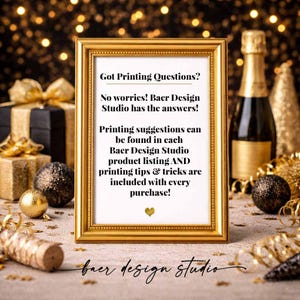 May include: A framed gold-colored sign with the text "Got Printing Questions?" and additional text about printing suggestions and tips. The sign is on a table with a gift box, ornaments, and a champagne bottle in the background. The Baer Design Studio logo is at the bottom.