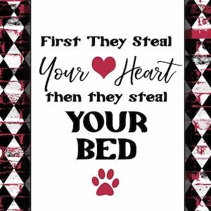 May include: A white sign with black text that reads "First they steal your heart then they steal your bed" with a red heart and paw print.