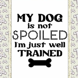 May include: A white sign with a black border and a black bone at the bottom. The sign reads "My dog is not spoiled I'm just well trained."