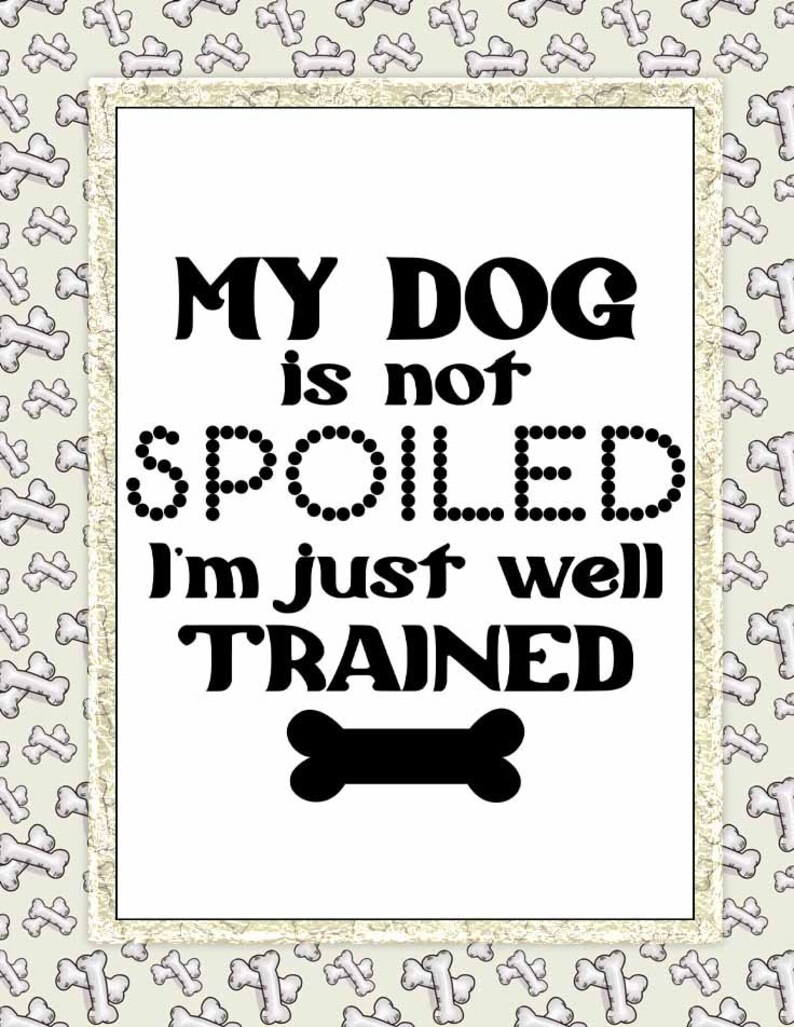 May include: A white sign with a black border and a black bone at the bottom. The sign reads "My dog is not spoiled I'm just well trained."
