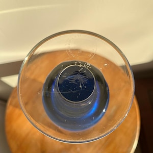 Op de afbeelding: Een heldere glazen vaas met een diepblauwe binnenkant. De vaas staat op een houten oppervlak. Het nummer "1269" is op de bodem van de vaas ge&euml;tst.