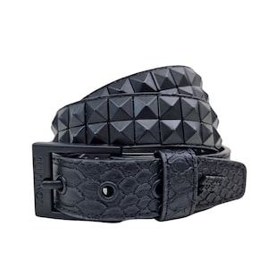 May include: Black studded belt with a snakeskin texture. The belt has pyramid studs and a black buckle with the text "LOWLIFE". A fashionable accessory for various outfits.