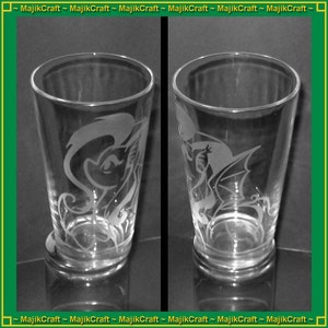 May include: Two clear glass tumblers with etched designs. One tumbler features a white silhouette of a pony with a flowing mane. The other tumbler features a white silhouette of a dragon with wings.