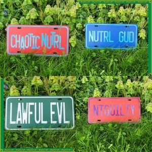 May include: Four license plates with different phrases on them. The plates are red, blue, green, and orange. The phrases are "CHAOTIC NUTRL", "NUTRL GUD", "LAWFUL EVL", and "NTGUILTY".