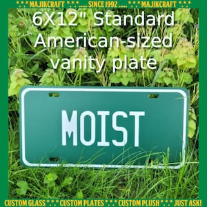 May include: A green 6x12 inch standard American-sized vanity plate with white lettering that reads "MOIST".