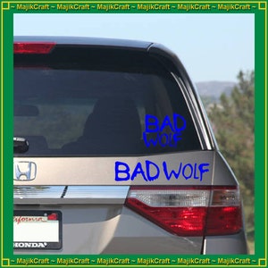 May include: A silver car with a blue "BAD WOLF" sticker on the back window.