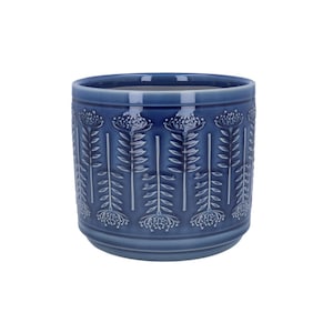 Puede incluir: Una maceta de cerámica azul con un estampado floral. La maceta cilíndrica presenta un diseño en relieve de flores y hojas estilizadas. La maceta es de color azul liso y tiene un acabado liso y brillante. Adecuada para uso en interiores o exteriores.