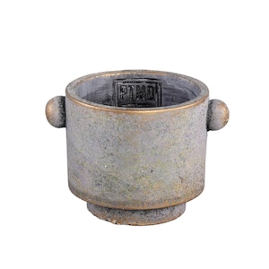 May include: A cylindrical pot with a weathered, mottled grey and gold finish. The vessel features two small, rounded side handles and a stepped base. Inside the rim, a rectangular plaque is embossed with the letters PTMD in a bold, dark font.