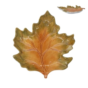 May include: A ceramic serving dish shaped like a large maple leaf with a glossy finish. The surface features a gradient of warm orange in the center transitioning to deep olive green along the jagged, textured edges with raised vein details.