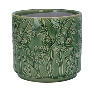 May include: A green ceramic plant pot with a detailed floral relief pattern. The pot has a cylindrical shape with a slightly flared rim and a base. The embossed design features various flowers and foliage, creating a textured surface.