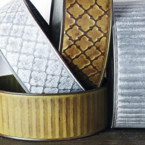 Puede incluir: Una colección de macetas decorativas de metal en varios estilos. Las macetas incluyen un diseño plateado en relieve, un patrón de cuatro hojas dorado, un diseño dorado acanalado y un estilo de metal galvanizado.